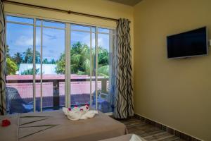 a room with a large window and a television at Relax Residence Thoddoo Maldives in Thoddoo
