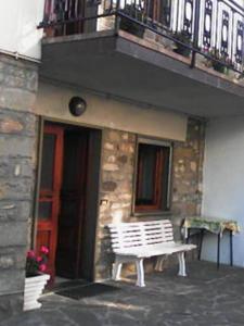 eine weiße Bank vor einem Gebäude mit Balkon in der Unterkunft Appartamento Montefumaiolo in Balze