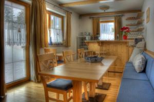 a living room with a wooden table and a blue couch at Haus Lowe in Filzmoos