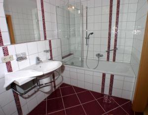 een badkamer met een wastafel, een douche en een bad bij "schön-urlauben" in Gröbming