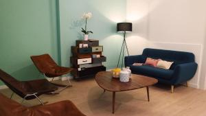 sala de estar con sofá azul y mesa en IndispArte Suites en Bérgamo