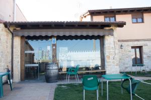 un patio con sillas verdes y una mesa en La Cerca de Doña Jimena, en Modúbar de San Cibrián