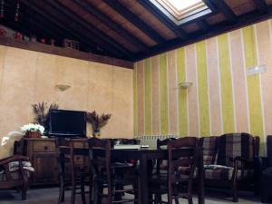 une salle à manger avec une table, des chaises et une télévision dans l'établissement La Cerca de Doña Jimena, à Modúbar de San Cibrián