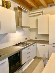 a kitchen with white cabinets and a stove top oven at Palazzo Penzo Bellemo in Chioggia
