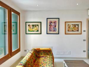 a living room with a couch and four pictures on the wall at Palazzo Penzo Bellemo in Chioggia