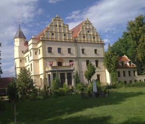 un gran edificio blanco con una torre en la cima de un campo en Zamek w Czernej, en Czerna