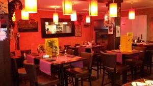 a restaurant with tables and chairs and red walls at O Barcaiolo in Conflans-Sainte-Honorine