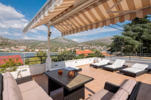 a patio with furniture and a view of the water at Villa Silvio in Seget Vranjica
