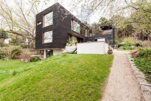 a black house on a hill with a garden at Ferienwohnung am Einsteinhaus Caputh in Caputh