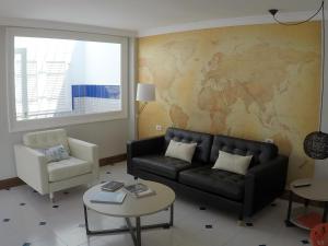 sala de estar con sofá y mapa en la pared en Fantastica vivienda en Playa de San Agustin con piscina, en San Agustín