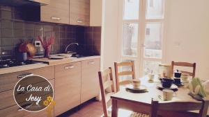 a kitchen with a table and chairs and a table and a table and a kitchen at La Casa Di Jesy in Lucca
