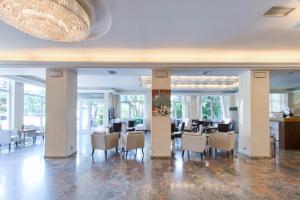 uma sala de jantar com cadeiras e mesas num edifício em Hotel London em Atenas
