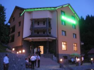 un edificio con una luce verde sul lato di Pension Waldburg a Rîşnov