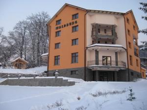 un hotel nella neve in inverno di Pension Waldburg a Rîşnov
