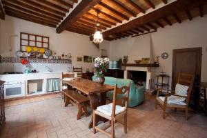 a kitchen and living room with a wooden table and chairs at Casa Corradini in Sarteano