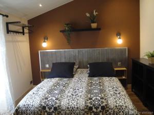 a bedroom with a bed with a black and white comforter at Gîte Le Vintage in Saint-Émilion