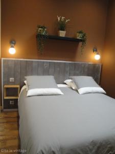 a bedroom with a large white bed with two pillows at Gîte Le Vintage in Saint-Émilion