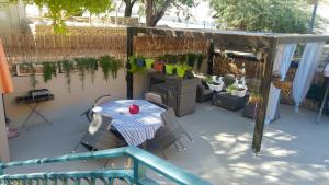 eine Terrasse mit Tisch, Stühlen und Pflanzen in der Unterkunft Martini Dead Sea in Neve Zohar