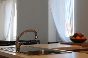 a kitchen counter with a sink and a bowl of fruit at Sea Apartment in Sanremo