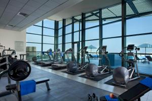 einen Fitnessraum mit Kardiogeräten und einem Pool in der Unterkunft Ascott Park Place Dubai in Dubai