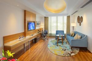 a living room with a blue couch and a tv at Radisson Blu Jammu in Jammu