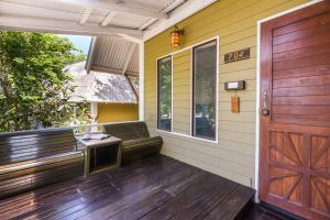 a porch of a house with a wooden door at Cocohut Beach Resort Koh Phangan in Haad Rin