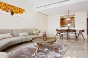a living room filled with furniture and a table at Bespoke Holiday Homes - Bay Square in Dubai