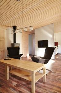 ein Wohnzimmer mit einem Holztisch und einem Sofa in der Unterkunft Käringsund Resort in Eckerö