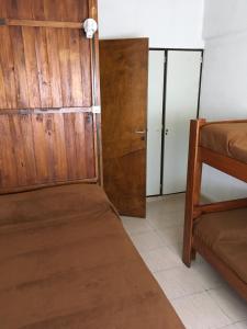 a room with a bed and a wooden door at Aconcagua in Miramar
