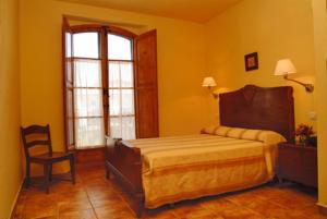 a bedroom with a bed and a chair and a window at Casa Rural Las Avutardas in Sierra de Fuentes