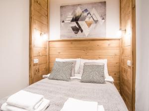 um quarto com uma cama com duas almofadas em TatryTop Apartamenty Szymaszkowa Ski Premium em Zakopane