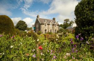 a house with a field of flowers in front of it at Bridgend Hotel in Bridgend