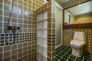 a bathroom with a toilet and a shower and a mirror at Cocohut Beach Resort Koh Phangan in Haad Rin