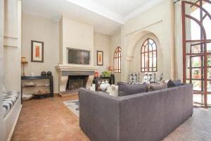 Le Cazar في El Aïn: غرفة معيشة مع أريكة ومدفأة