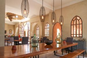 - une salle à manger avec une table et des vases dans l'établissement Le Cazar, à El Aïn