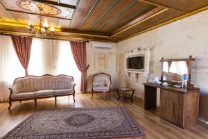 una sala de estar con un sofá y una mesa en Cappadocia Empire Cave Hotel, en Göreme