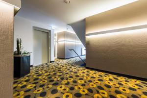 a hallway with yellow and black flowers on the floor at Hof Veldink in Emlichheim