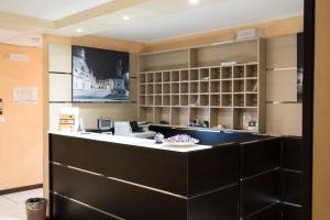 a large kitchen with a black counter and shelves at Hotel Corte Business in Cavriago