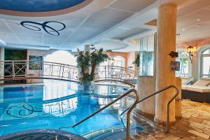 a large swimming pool with stairs in a building at Sporthotel Cinderella in Obertauern