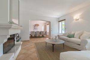 a living room with a couch and a table at Villa LAURIERS ROSES Saint Tropez in Saint-Tropez