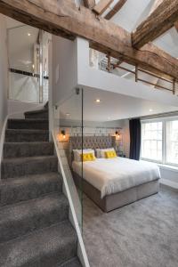 a bedroom with a large bed and a staircase at The Lawrence in Burnley