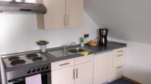 a kitchen with a sink and a stove top oven at Haus Schnorbus in Hallenberg