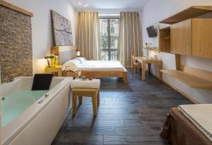 ein Hotelzimmer mit einer Badewanne und einem Schlafzimmer in der Unterkunft AQUAROOMS Luxury Suites in Palermo