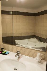 ein Badezimmer mit einer Badewanne und einem Waschbecken in der Unterkunft Hotel Corte Business in Cavriago