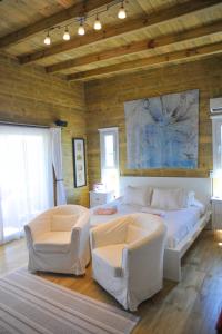 a bedroom with a large bed and two chairs at Mar y Arena - Mar de Amor - Delux José Ignacio in José Ignacio