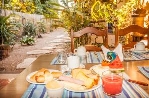 a wooden table with plates of food on it at Pousada Mundo Dha Lua in Sao Jorge