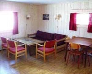 uma sala de estar com um sofá, uma mesa e cadeiras em Kvanhøgd Turistsenter em Gol
