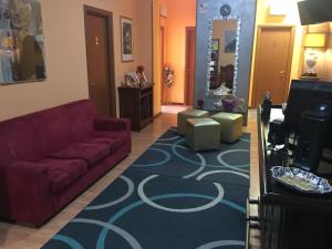 een woonkamer met een rode bank en een blauw tapijt bij Locanda Beatrice in Sanremo