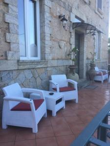 um grupo de cadeiras e uma mesa num pátio em Residenza Casale San Francesco em Tropea