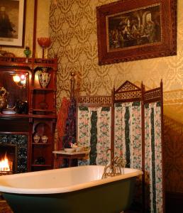 a bathroom with a bath tub and a fireplace at The Richards House in Dubuque